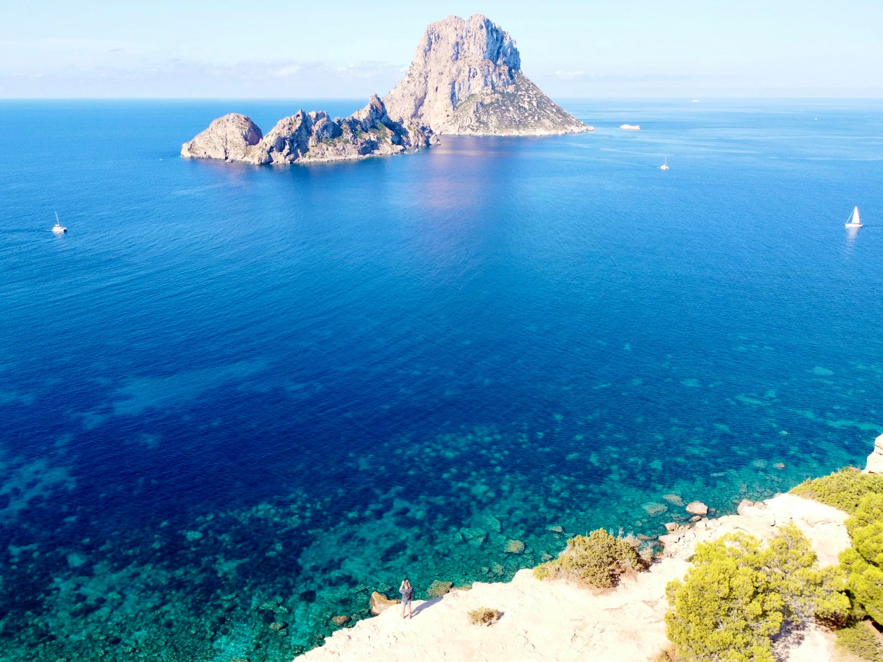 Blick auf den Felsen Es Vedrà vor Ibiza mit türkisfarbenem, kristallklarem Meer