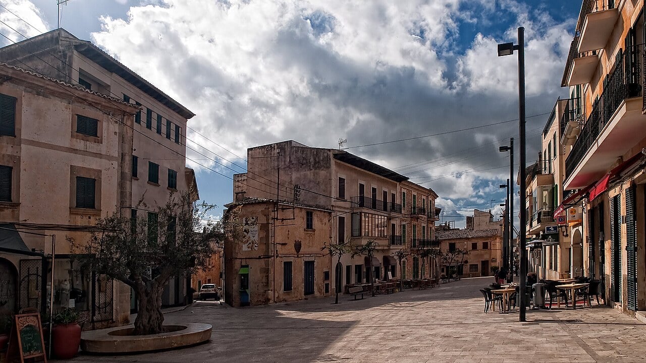 Die Plaza Mayor von Santanyí auf Mallorca mit honigfarbenen Sandsteinfassaden und Straßencafés