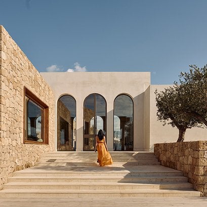 Entrance of PHOS restaurant with wide stone steps and tall arched windows