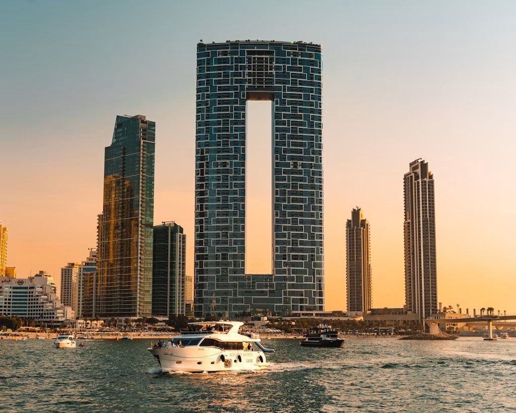 Skyline von Downtown Dubai bei Sonnenuntergang mit Yachten im Wasser