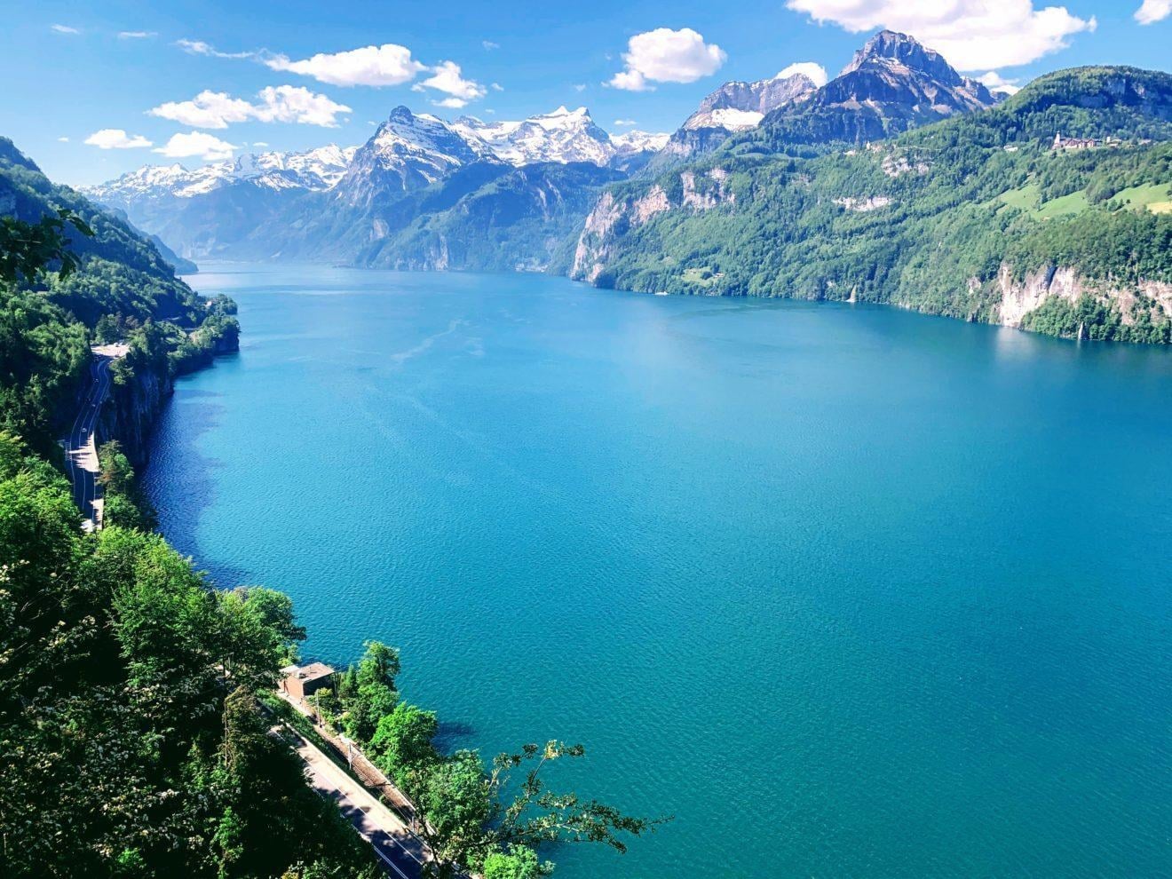 Türkisfarbener Bergsee umgeben von schneebedeckten Alpengipfeln