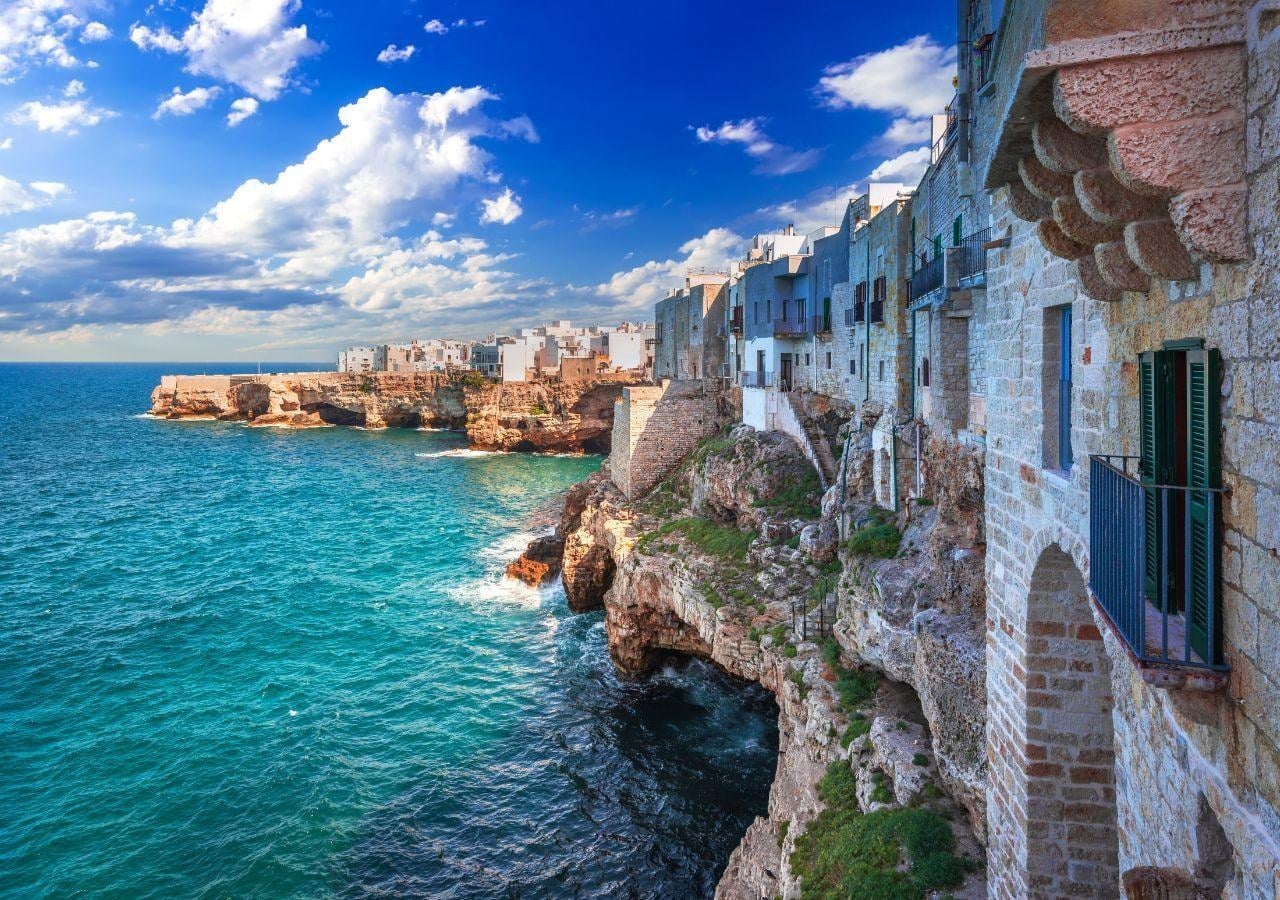 Die Steilküste von Polignano a Mare in Apulien mit Häusern auf den Klippen