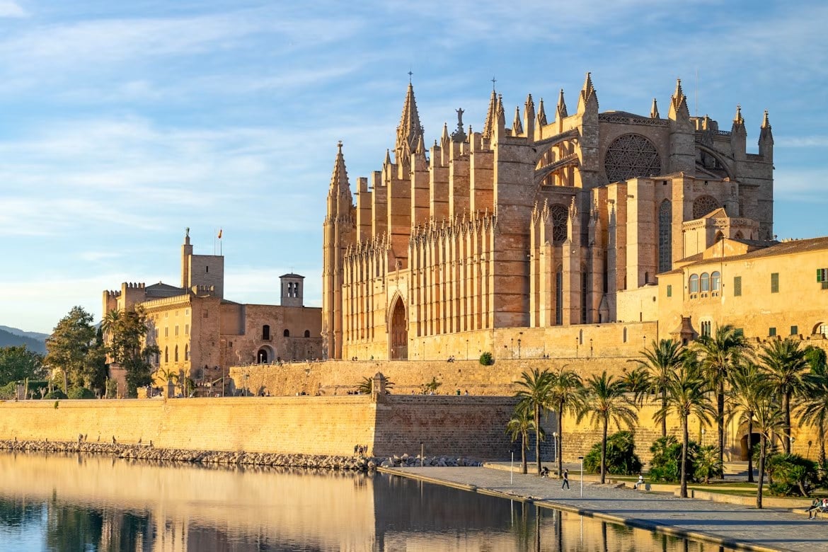 Kathedrale La Seu in Palma de Mallorca bei goldenem Licht mit Spiegelung im Wasser