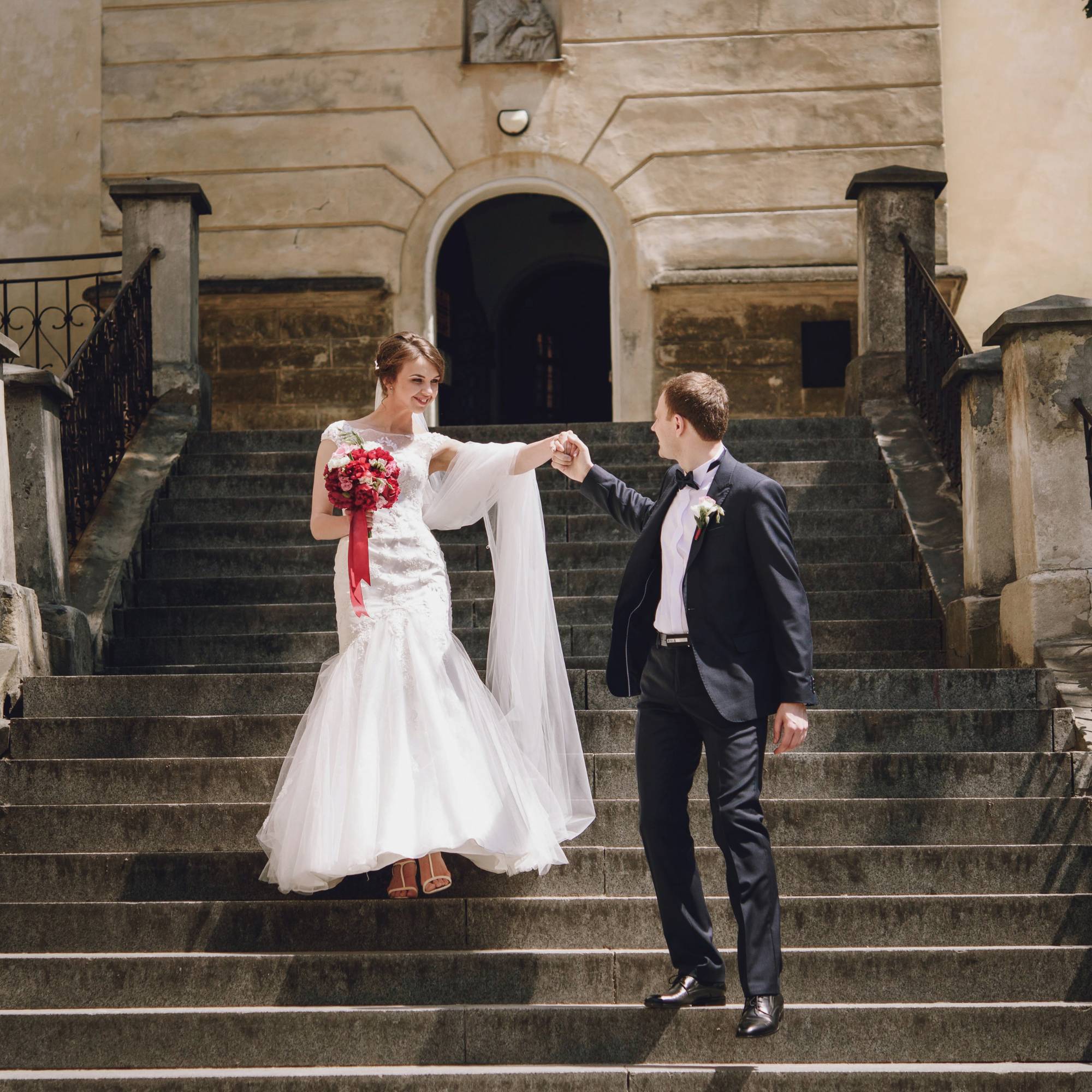 Brautpaar Hand in Hand auf einer historischen Treppe